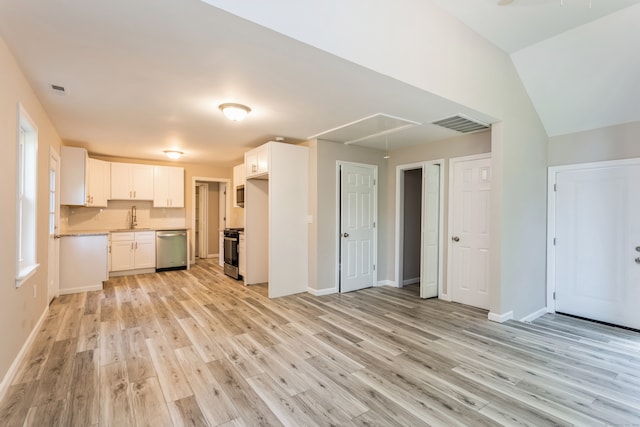 kitchen with light wood-type flooring, range, stainless steel dishwasher, white cabinets, and lofted ceiling