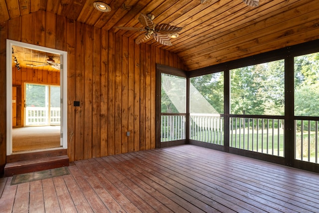 unfurnished sunroom with ceiling fan, a healthy amount of sunlight, and wood ceiling