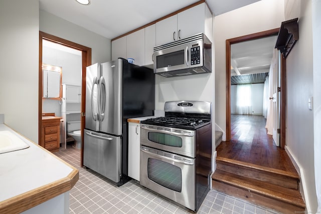 kitchen with white cabinetry, stainless steel appliances, light hardwood / wood-style flooring, and sink