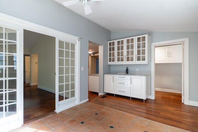 bar featuring white cabinetry, ceiling fan, wood-type flooring, and vaulted ceiling