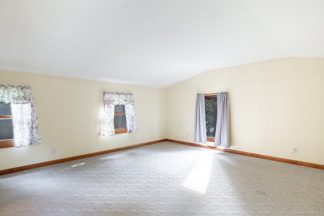 empty room featuring vaulted ceiling and carpet floors