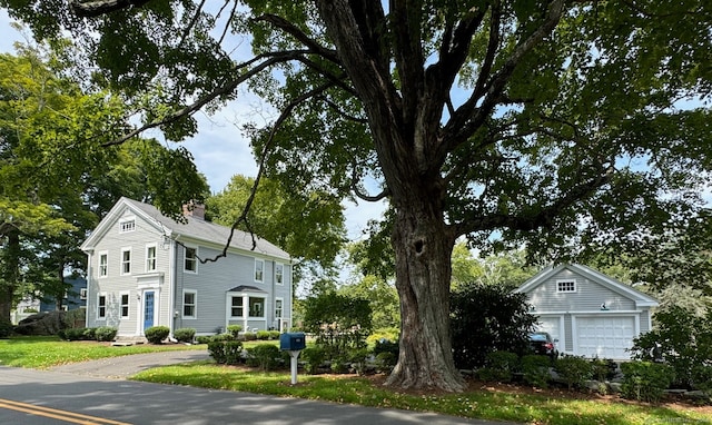 view of front of home with a garage and an outbuilding