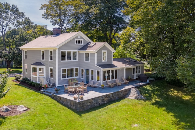 back of house featuring a lawn and a patio