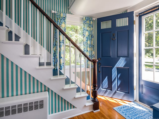 foyer entrance featuring radiator heating unit and hardwood / wood-style flooring