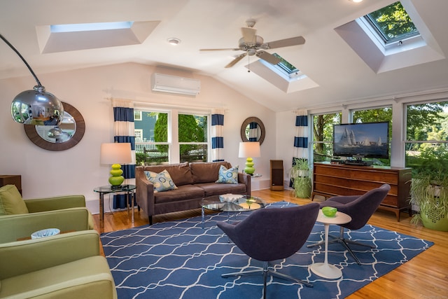 living room featuring wood-type flooring, vaulted ceiling with skylight, an AC wall unit, and ceiling fan