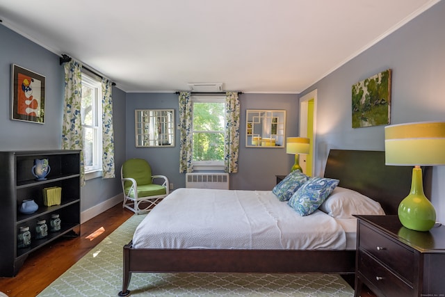 bedroom featuring crown molding, radiator heating unit, and dark hardwood / wood-style flooring