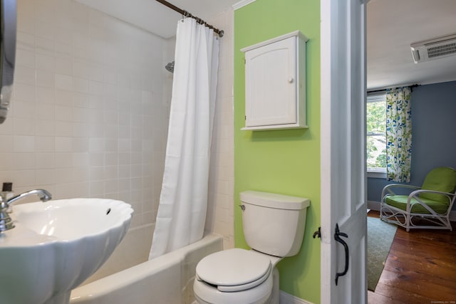 full bathroom with wood-type flooring, toilet, shower / tub combo, and sink