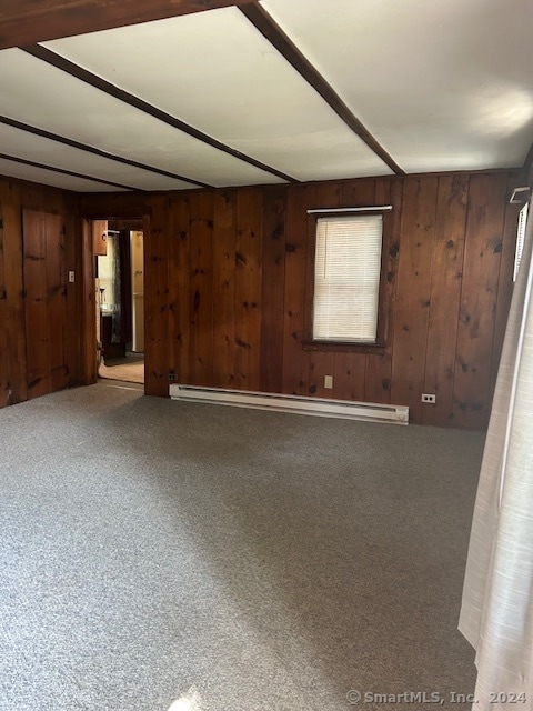 spare room featuring wooden walls, carpet floors, and baseboard heating