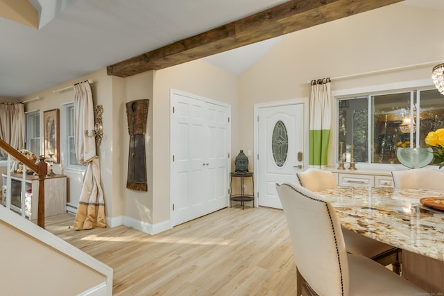 dining area with a baseboard heating unit, light hardwood / wood-style flooring, and lofted ceiling with beams