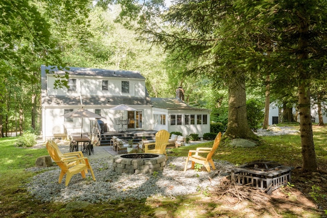 rear view of property featuring an outdoor fire pit