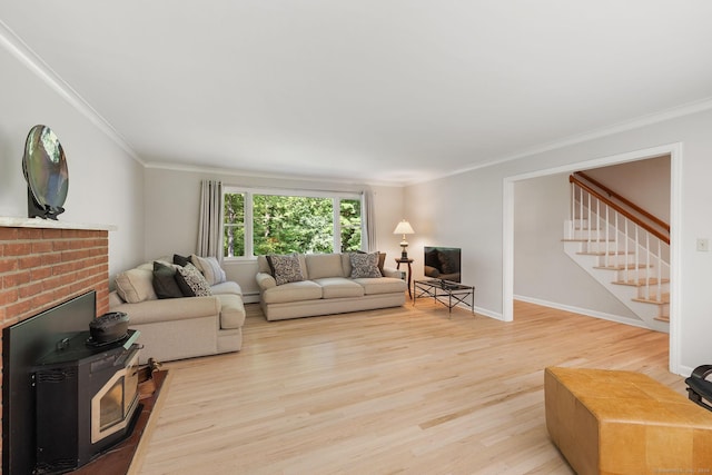 14 Stilson Ln, New Milford, CT 06776 - living room with light wood-style flooring, crown molding, a wood stove, and stairs