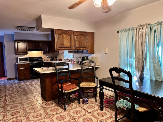 68 Todd St, Hamden, CT 06518 - kitchen featuring ventilation hood, light countertops, stainless steel microwave, gas stove, and a peninsula