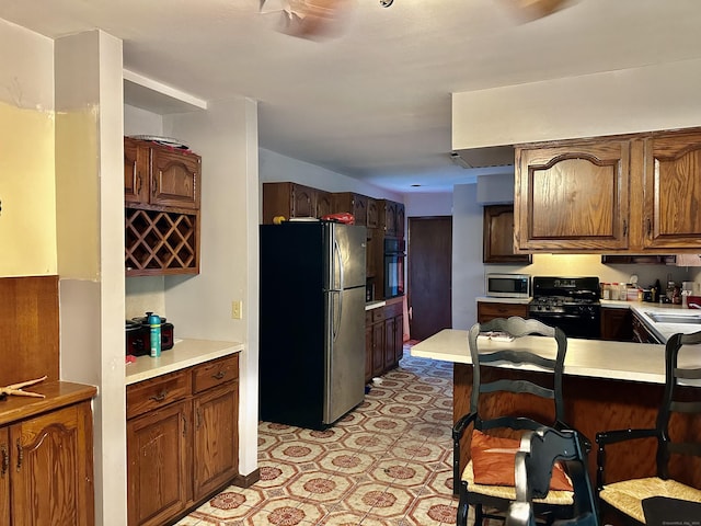 68 Todd St, Hamden, CT 06518 - kitchen featuring light floors, light countertops, a sink, a kitchen bar, and appliances with stainless steel finishes