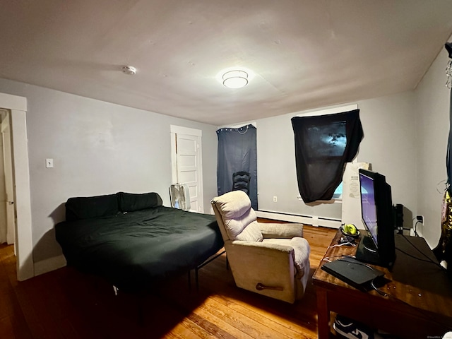 bedroom with a baseboard radiator and hardwood / wood-style flooring