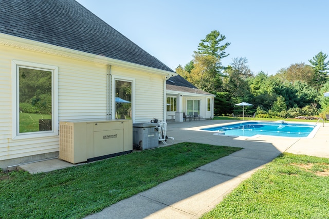 view of swimming pool featuring a lawn, a diving board, and a patio area