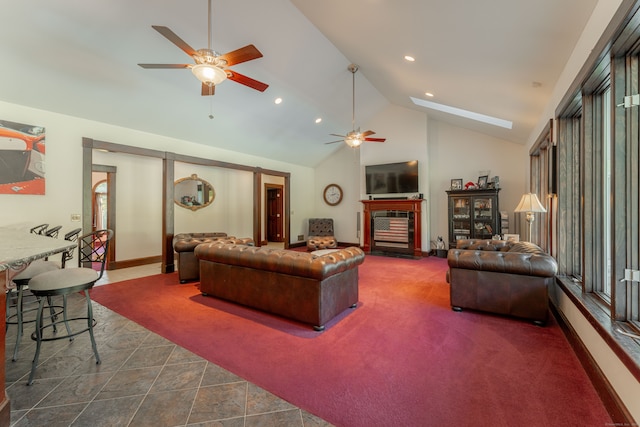 tiled living room featuring high vaulted ceiling, a skylight, and ceiling fan