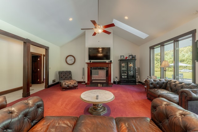 carpeted living room with high vaulted ceiling, a skylight, ceiling fan, and a fireplace