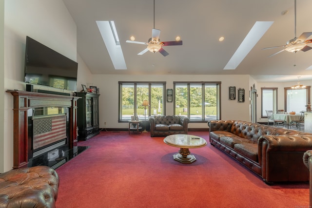 carpeted living room with high vaulted ceiling, a skylight, and ceiling fan