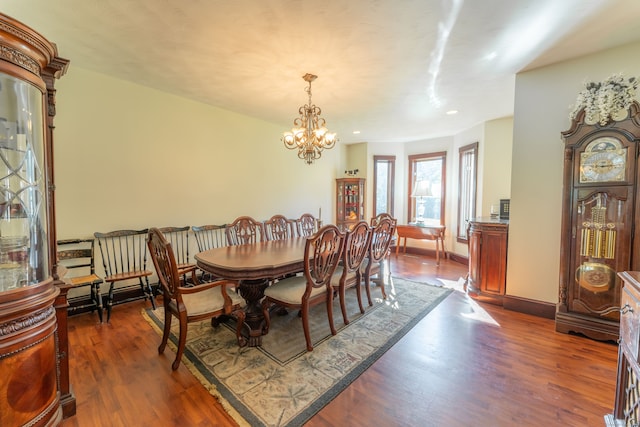 dining space with dark hardwood / wood-style floors and a notable chandelier