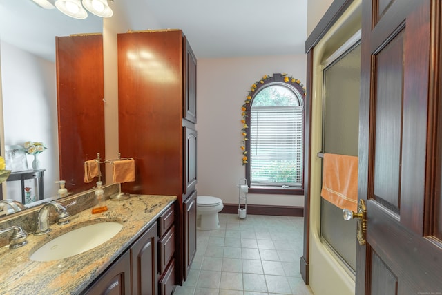 full bathroom with a healthy amount of sunlight, toilet, vanity, and tile patterned floors