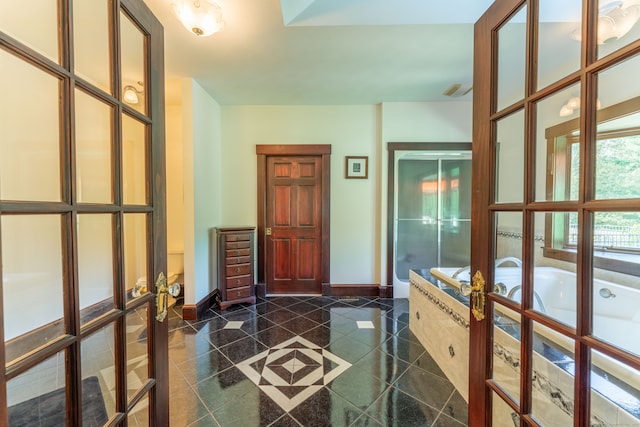 corridor with french doors and dark tile patterned flooring