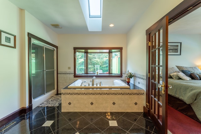 bathroom featuring tile patterned flooring, separate shower and tub, and a skylight