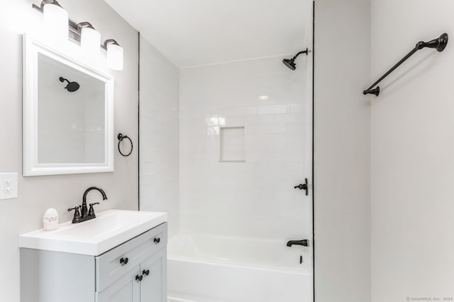 bathroom with tiled shower / bath and vanity