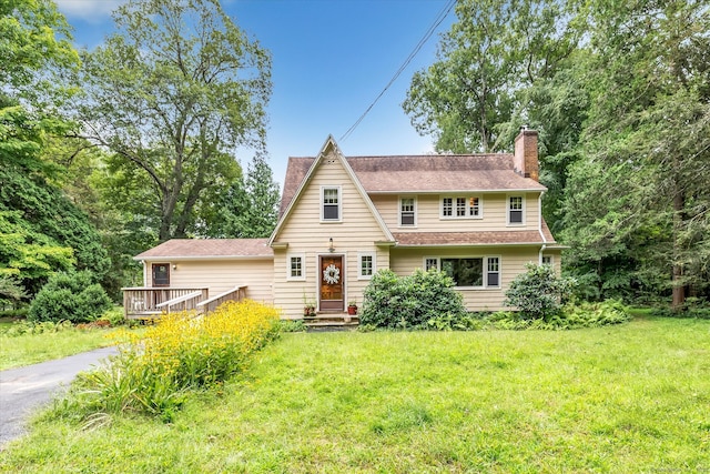 view of front of home featuring a wooden deck and a front lawn