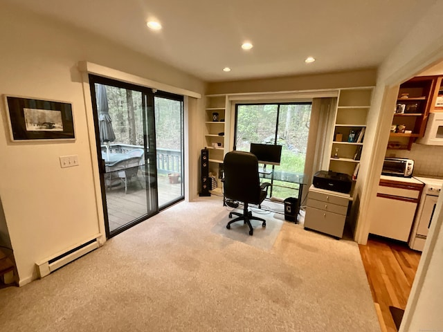 office space with a baseboard heating unit, recessed lighting, and light carpet