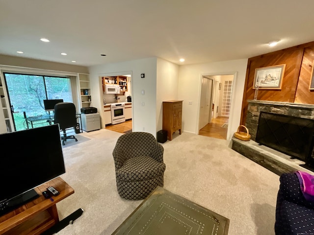 living room featuring light carpet and a stone fireplace