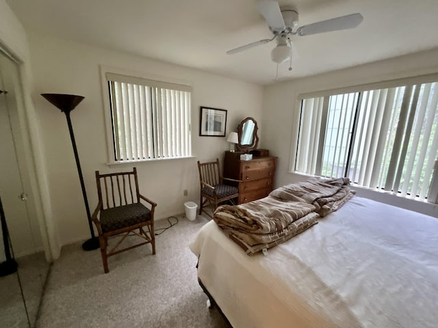 carpeted bedroom with a ceiling fan and multiple windows