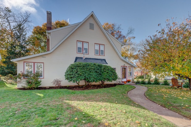 view of home's exterior featuring a lawn and a chimney