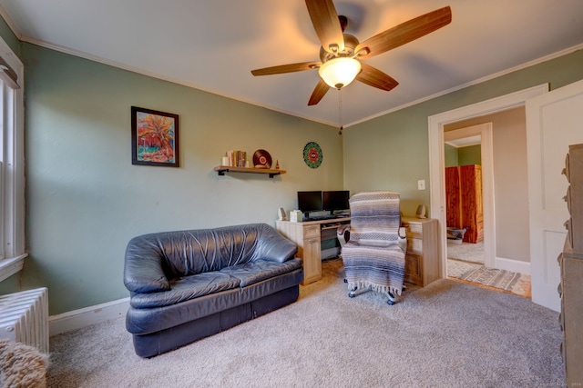 living room featuring ceiling fan, baseboards, ornamental molding, and carpet flooring