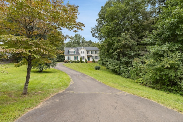 colonial inspired home with a front lawn