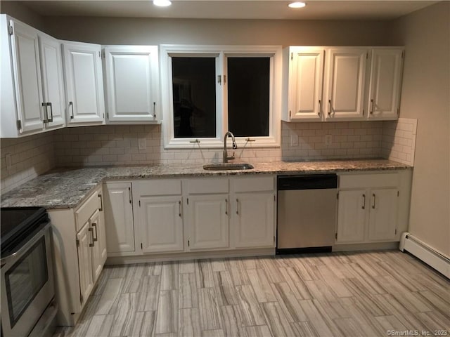 kitchen featuring backsplash, stainless steel appliances, white cabinetry, sink, and light stone countertops