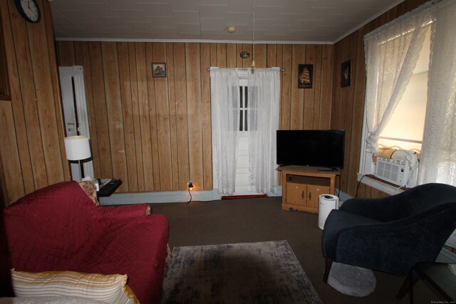 living room with carpet, wooden walls, cooling unit, and ornamental molding