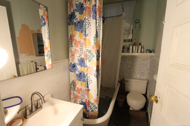 bathroom featuring curtained shower, vanity, and toilet