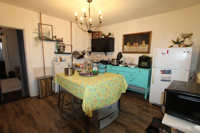 kitchen featuring a notable chandelier, blue cabinetry, dark hardwood / wood-style floors, and white fridge