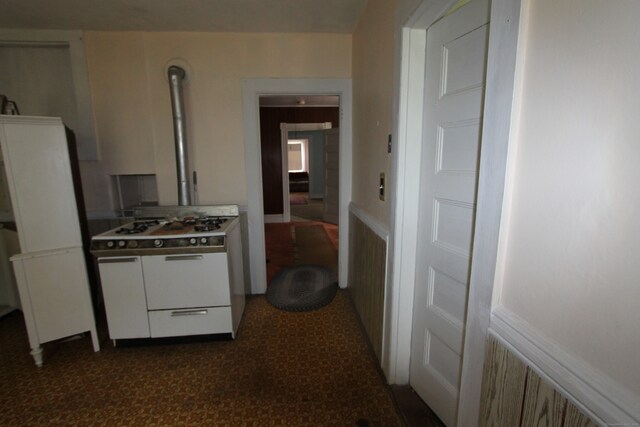 kitchen with white gas stove and white cabinets