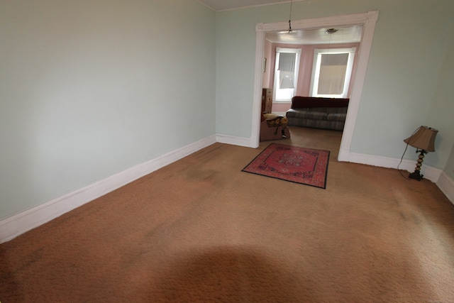 carpeted empty room featuring crown molding