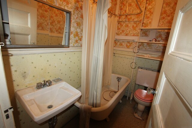 bathroom featuring sink, toilet, and a tub