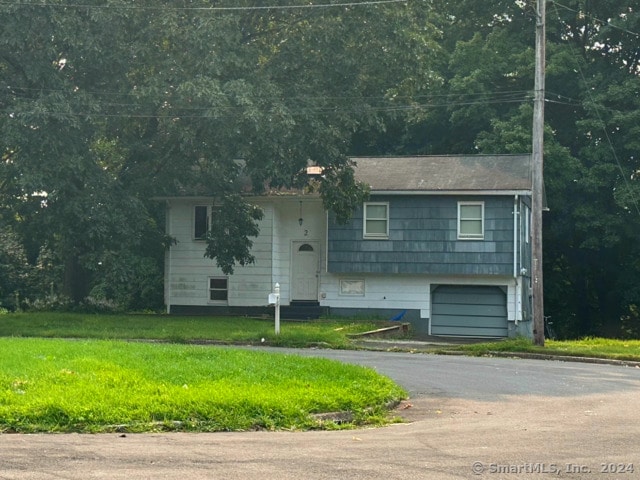 view of front of house featuring a garage and a front lawn