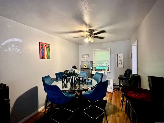 dining room with a textured ceiling, ceiling fan, and wood-type flooring