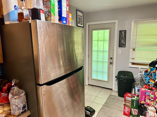 interior space with stainless steel fridge and light tile patterned floors