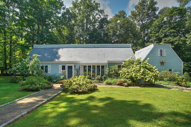 view of front of house featuring roof with shingles and a front lawn