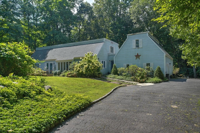 colonial inspired home featuring aphalt driveway and a front yard