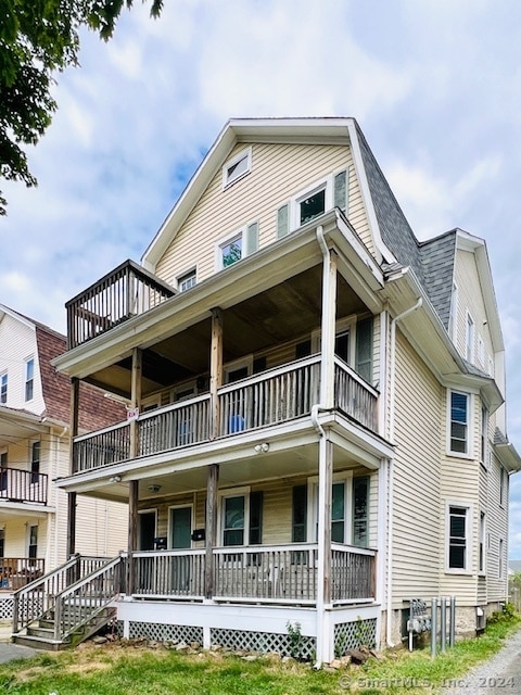 rear view of house featuring a porch and a balcony