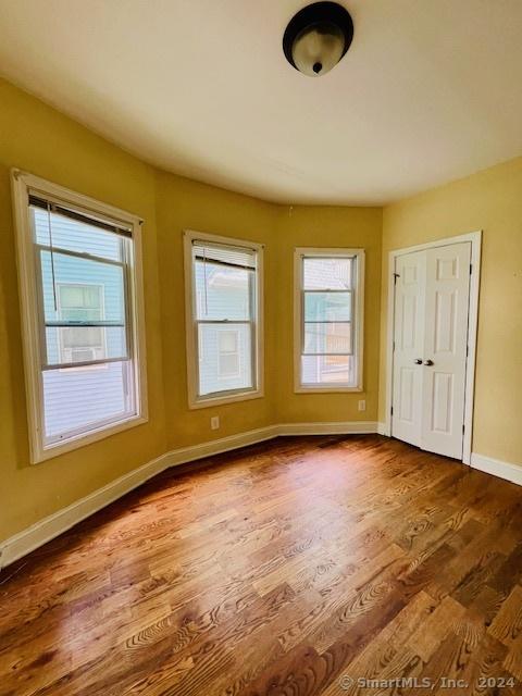 unfurnished room with wood finished floors and baseboards