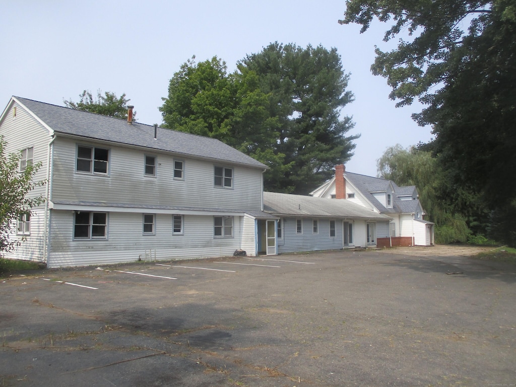 back of house featuring uncovered parking