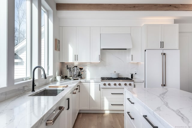 kitchen with ventilation hood, light hardwood / wood-style floors, white cabinetry, sink, and built in refrigerator